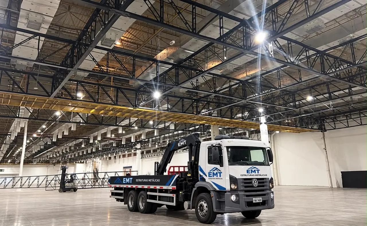 Caminhão munck da EMT sob estrutura treliçada de cobertura em pavilhão